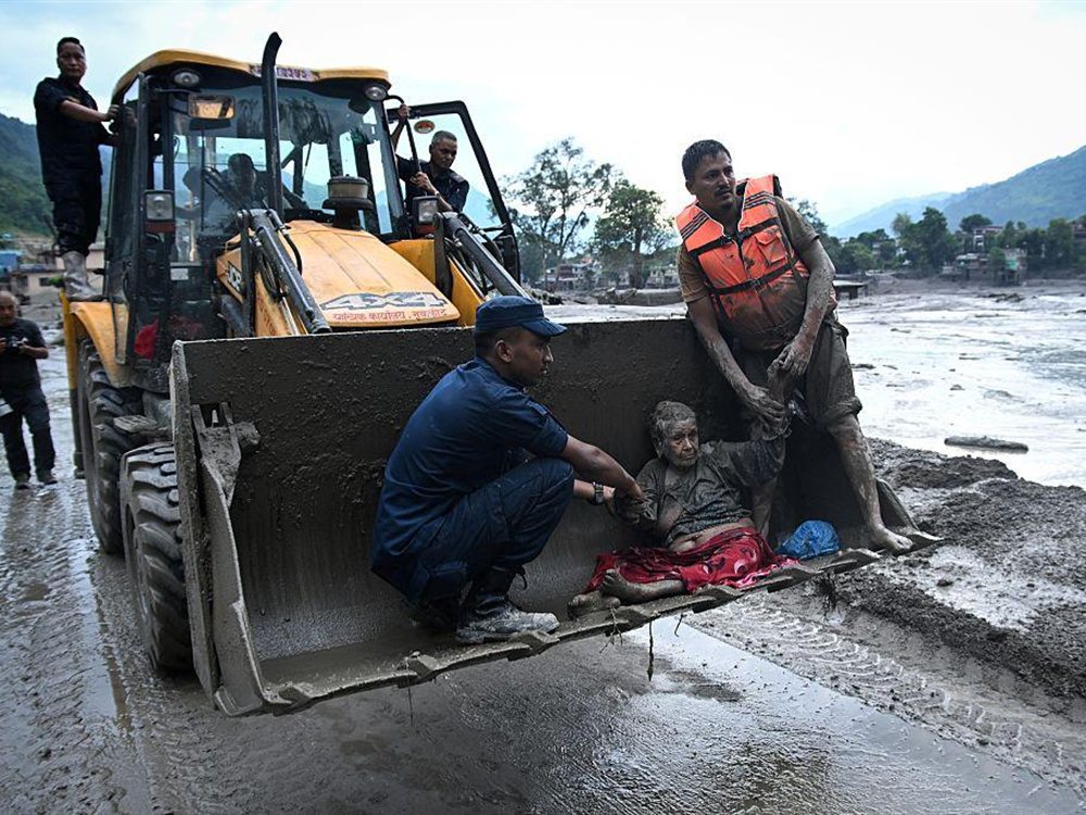 Emergency workers assisting a person following the floods